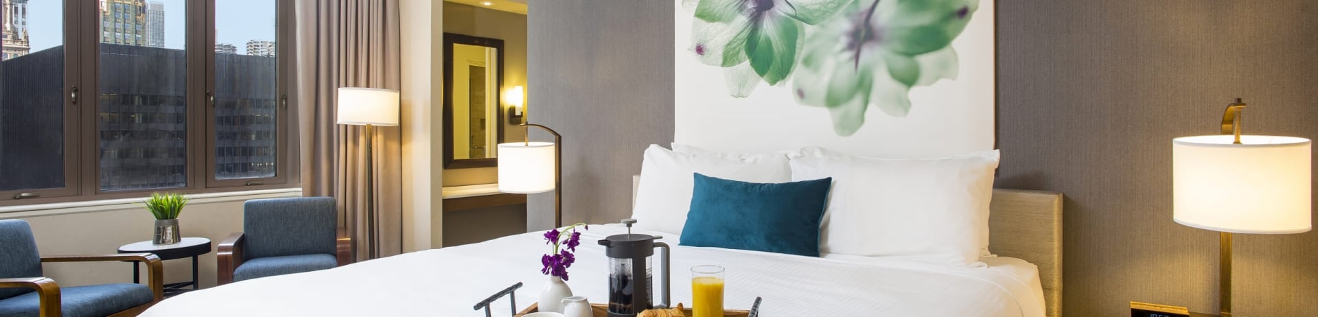 bedroom with small sitting area and breakfast tray on bed