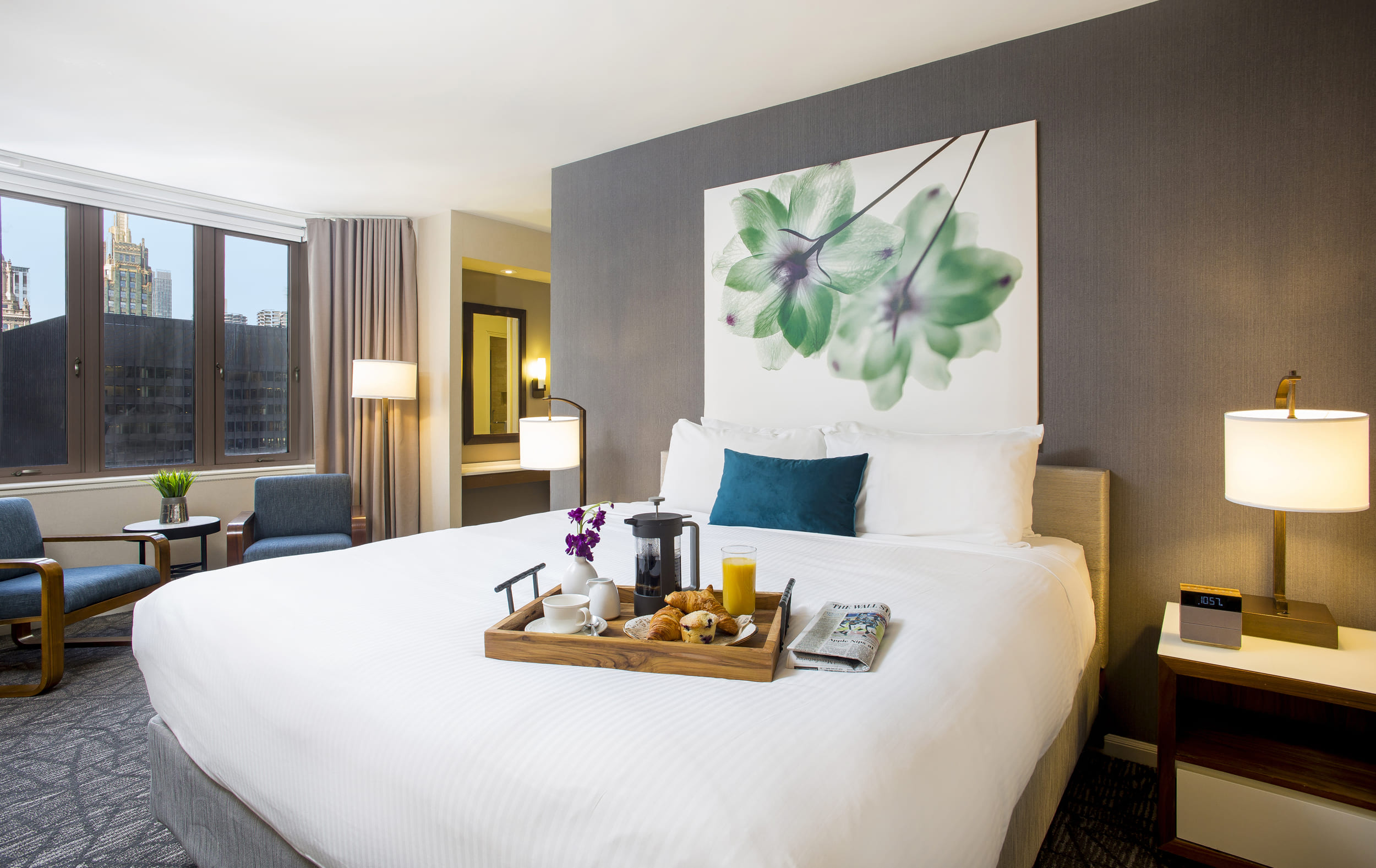 bedroom with small sitting area and breakfast tray on bed